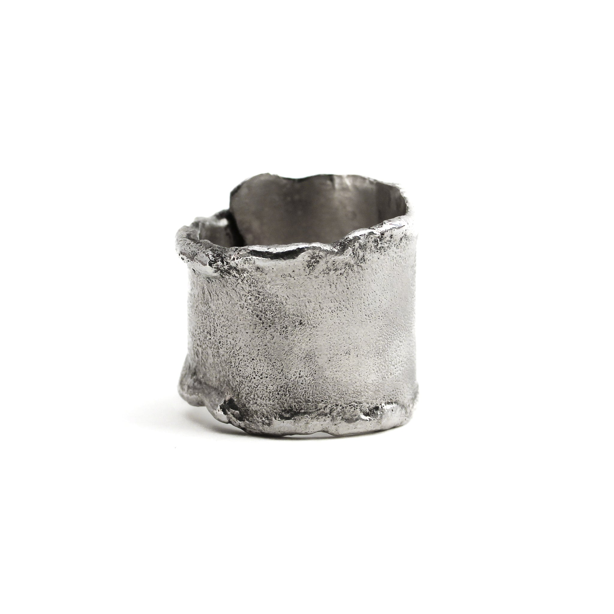 Back of sterling silver overlapping wrap ring with melted edges and an oxidized rustic surface texture. 