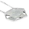 Load image into Gallery viewer, Back of asymmetric hexagonal pendant with a brushed matte sterling silver finish. Logo saying Zed Eh is stamped on edge of pendant, in black. Square link chain attached to pendant is blurred, on a white background
