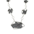 Load image into Gallery viewer, Front view of a modern sterling silver pendant, featuring a large central asymmetric, hexagon framing a fused and brutalist textured blackplate with melted holes. There are 2 more hexagons of descending size on either side, separated by an inch of square link chain with a smaller, hexagonal link in the middle.
