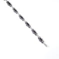 Load image into Gallery viewer, Unique industrial sterling silver bicycle-style chain bracelet. Every other link features a textured black finish with a 3mm tube soldered in the center on both sides and the alternate link is smooth and polished. Each link is connected by roughly finished rivets. Top down view of undone bracelet, laying flat across the background, highlighting a top view of the links and hook clasp. 
