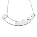 Load image into Gallery viewer, Back of necklace crafted from two long curved square wires connected at one end and split at the other. An angular sheet of silver is positioned between the wires. On the right side of the top curved bar, three 10-millimeter stones are set and on the left side, suspended between the ends of the curved bars, is a large bezel. The entire back of necklace is polished to a matte brushed finish. The pendant is attached to a link-in-link chain.
