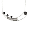 Load image into Gallery viewer, Necklace crafted from two long curved square wires with random black lines, connected at one end and split at the other. An angular sheet of blackened textured silver is positioned between the wires. On the right side of the top curved bar, three 10-millimeter stones are set – two black onyx and one silver mesh dome. On the left side, suspended between the ends of the curved bars, is a large bezel made of domed silver mesh. The pendant is attached to a link-in-link chain.
