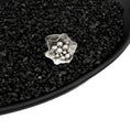 Load image into Gallery viewer, Sterling silver, handmade, freeform flower ring filled with several asymmetric varying sized balls, in a black dish filled with black pebbles on white background. 
