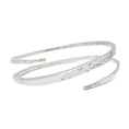 Load image into Gallery viewer, Sterling silver bracelet with a hammered texture. The bangles ends bypass eachother and create a single coil.  It is thicker in the middle and tapers towards either end. Bracelet is on a white background and facing forward
