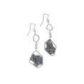 Load image into Gallery viewer, Sterling silver modern dangle earrings, on white background. Each earring has a larger hexagon framing a blackened and brutalist textured backplate. This is attached to some square chain links, and smaller hexagon and finished with a square shaped ear wire.
