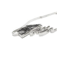 Load image into Gallery viewer, A modernist inspired handmade sterling silver necklace showcasing an undulating bar on the left side, mimicking soundwaves, culminating at the left side of an asymmetric pentagon hollowform. The hollowform has a blackened, heavily textured surface, evoking a brutalist sensibility. Emerging from the bottom of the hollowform, the silver bar creates the illusion of continuity as it curves upward, connecting to a bar and link chain. Pendant is laying on its side
